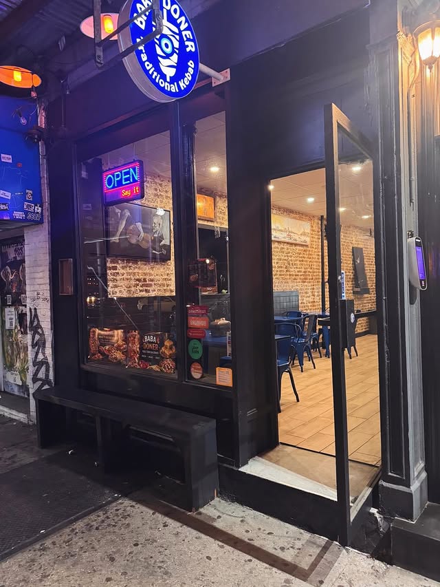 Baba Döner storefront at night with illuminated BABA DÖNER sign, OPEN neon, and glass entrance at 147 Avenue A East Village